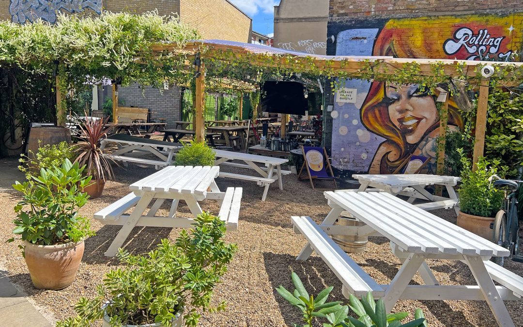 Outdoor garden at Rolling Stock London set up for World Cup screening with large crowd, drinks, and big screen in Shoreditch venue